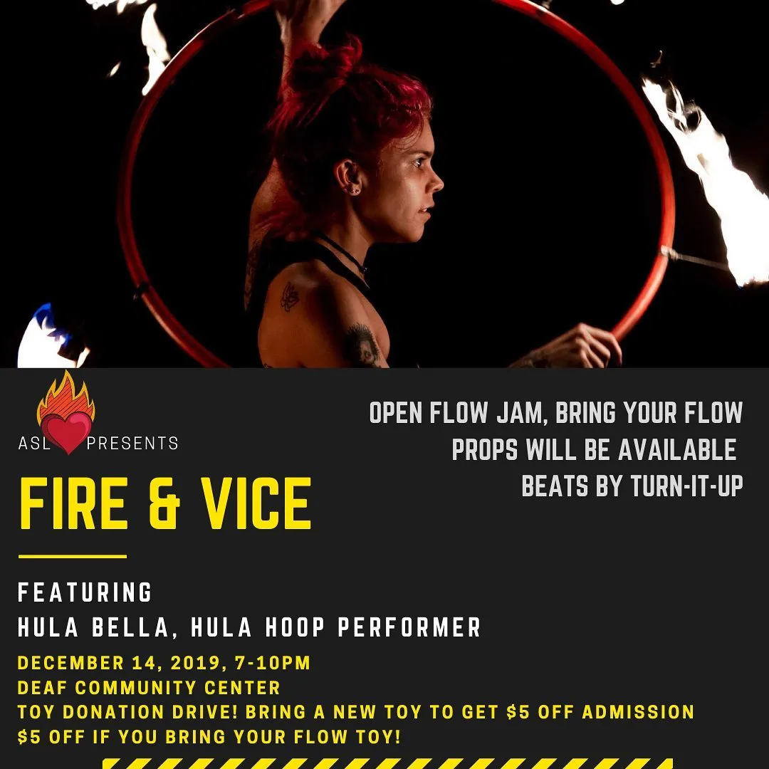 FIRE & VICE flyer. Across the top, a dramatic dark photo of performer Hula Bella — red mohawk, tattoos — spinning a flaming red hoop, fire streaking through the darkness. Below on a charcoal panel: the ASL Love heart-in-flames logo with 'ASL Presents,' then a bold yellow title 'FIRE & VICE.' Text: 'Featuring Hula Bella, Hula Hoop Performer. December 14, 2019, 7–10PM, Deaf Community Center. Toy Donation Drive! Bring a new toy to get $5 off admission. $5 off if you bring your flow toy!' To the right: 'Open flow jam, bring your flow. Props will be available. Beats by Turn-It-Up.'